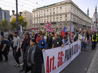 People hold signs and shout slogans as they rally against the Polish Prime Minister Donald Tusk's decision to suspend the right to asylum wi...