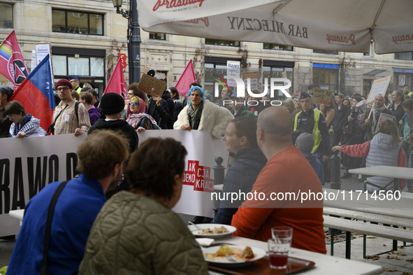 People hold signs and shout slogans as they rally against the Polish Prime Minister Donald Tusk's decision to suspend the right to asylum wi...