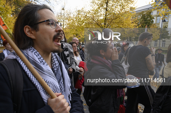 People hold signs and shout slogans as they rally against the Polish Prime Minister Donald Tusk's decision to suspend the right to asylum wi...