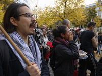 People hold signs and shout slogans as they rally against the Polish Prime Minister Donald Tusk's decision to suspend the right to asylum wi...