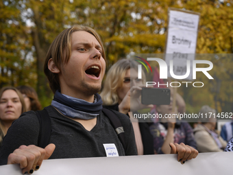 People hold signs and shout slogans as they rally against the Polish Prime Minister Donald Tusk's decision to suspend the right to asylum wi...