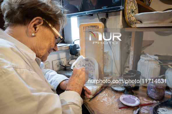 An artisan decorating ceramic object is seen in Deruta, Italy, on October 22nd, 2024. Deruta is the city par excellence of the artistic majo...