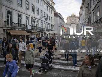 People walk along one of the streets in the Baixa district in Lisbon, Portugal, on October 27, 2024. (