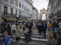 People walk along one of the streets in the Baixa district in Lisbon, Portugal, on October 27, 2024. (