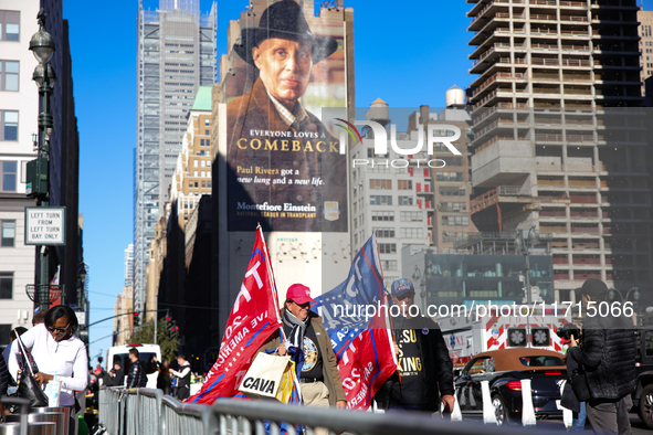 Supporters of Donald Trump carry flags outside of Madison Square Garden in New York, New York on October 27, 2024 as the former President ho...