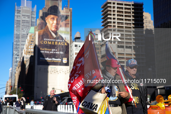 Supporters of Donald Trump carry flags outside of Madison Square Garden in New York, New York on October 27, 2024 as the former President ho...