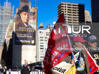 Supporters of Donald Trump carry flags outside of Madison Square Garden in New York, New York on October 27, 2024 as the former President ho...