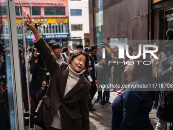 Artist Kwon Eun-bi introduces her work to Joanne Rached, the mother of foreign victim Grace Rached, at the opening ceremony of the new 10.29...