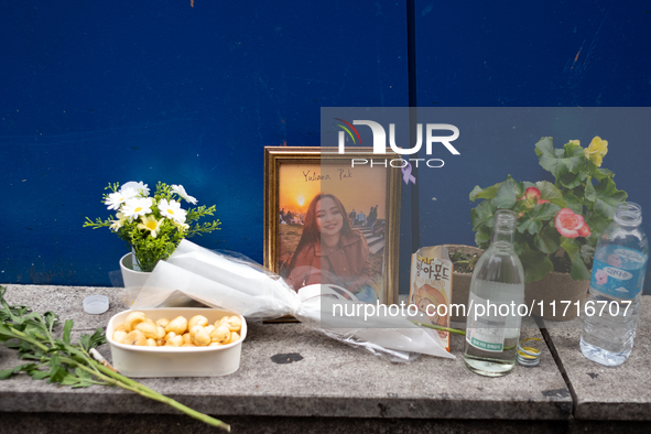 A memorial tribute for a victim of the Itaewon tragedy includes flowers, a framed photo, snacks, and drinks, placed in remembrance in the It...