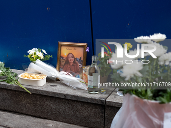 A memorial tribute for a victim of the Itaewon tragedy includes flowers, a framed photo, snacks, and drinks, placed in remembrance in the It...