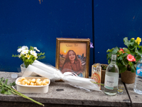 A memorial tribute for a victim of the Itaewon tragedy includes flowers, a framed photo, snacks, and drinks, placed in remembrance in the It...