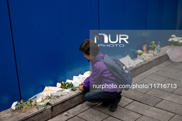 A bereaved family member places a flower after the billboard opening ceremony at the ''10.29 Path of Remembrance and Safety'' in the Itaewon...