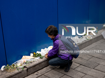 A bereaved family member places a flower after the billboard opening ceremony at the ''10.29 Path of Remembrance and Safety'' in the Itaewon...