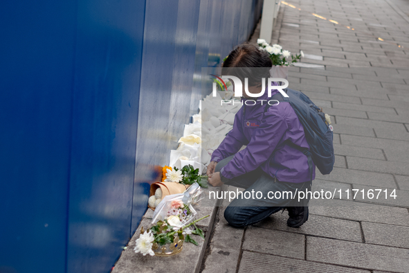 A bereaved family member places a flower after the billboard opening ceremony at the ''10.29 Path of Remembrance and Safety'' in the Itaewon...