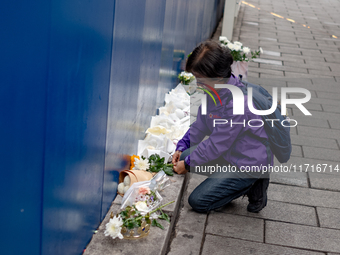 A bereaved family member places a flower after the billboard opening ceremony at the ''10.29 Path of Remembrance and Safety'' in the Itaewon...