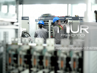 Workers produce power transmission equipment products at a workshop in Hai'an, Jiangsu province, China, on October 28, 2024. (