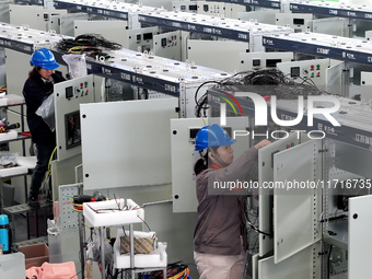 Workers produce power transmission equipment products at a workshop in Hai'an, Jiangsu province, China, on October 28, 2024. (