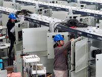 Workers produce power transmission equipment products at a workshop in Hai'an, Jiangsu province, China, on October 28, 2024. (