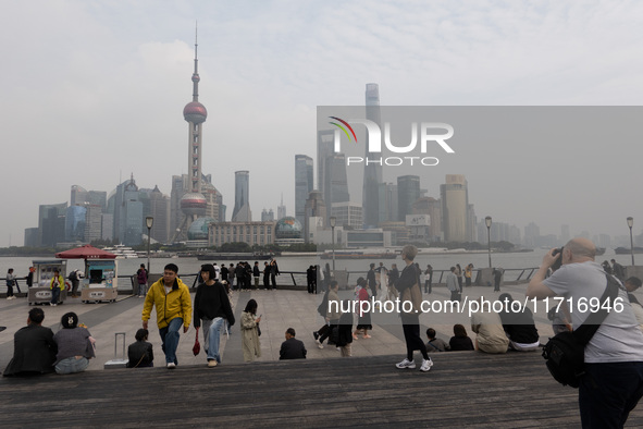 Tourists tour on a waterfront landscape platform along the Bund in Shanghai, China, on October 28, 2024. 