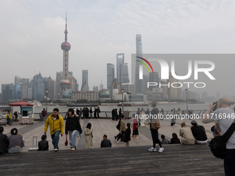 Tourists tour on a waterfront landscape platform along the Bund in Shanghai, China, on October 28, 2024. (