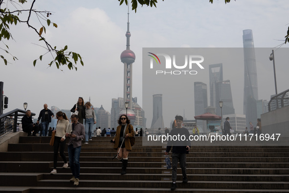 Tourists tour on a waterfront landscape platform along the Bund in Shanghai, China, on October 28, 2024. 