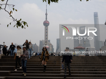 Tourists tour on a waterfront landscape platform along the Bund in Shanghai, China, on October 28, 2024. (