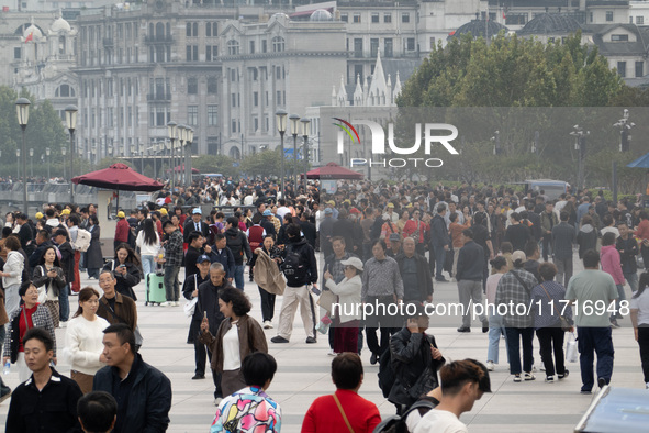 Tourists tour on a waterfront landscape platform along the Bund in Shanghai, China, on October 28, 2024. 