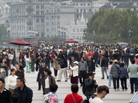 Tourists tour on a waterfront landscape platform along the Bund in Shanghai, China, on October 28, 2024. (