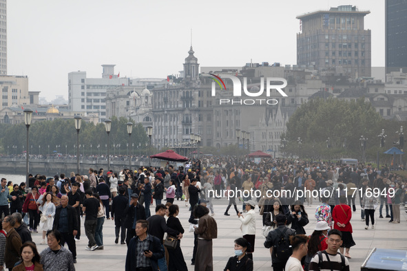 Tourists tour on a waterfront landscape platform along the Bund in Shanghai, China, on October 28, 2024. 