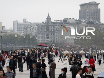 Tourists tour on a waterfront landscape platform along the Bund in Shanghai, China, on October 28, 2024. (