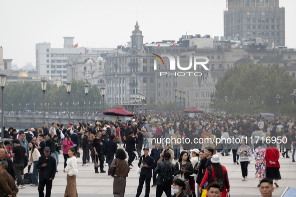 Tourists tour on a waterfront landscape platform along the Bund in Shanghai, China, on October 28, 2024. 