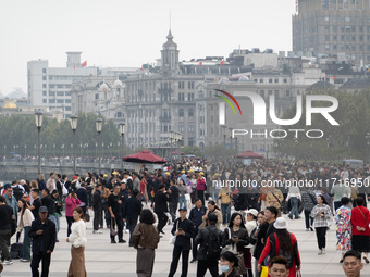 Tourists tour on a waterfront landscape platform along the Bund in Shanghai, China, on October 28, 2024. (