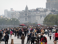 Tourists tour on a waterfront landscape platform along the Bund in Shanghai, China, on October 28, 2024. (