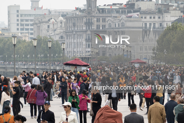 Tourists tour on a waterfront landscape platform along the Bund in Shanghai, China, on October 28, 2024. 