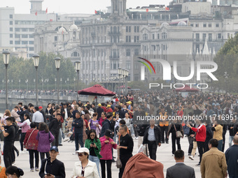 Tourists tour on a waterfront landscape platform along the Bund in Shanghai, China, on October 28, 2024. (