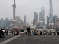 An anchor broadcasts a live webcast with the Lujiazui business district as the background on the Bund landscape platform in Shanghai, China,...