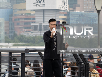 An anchor broadcasts a live webcast with the Lujiazui business district as the background on the Bund landscape platform in Shanghai, China,...