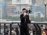 An anchor broadcasts a live webcast with the Lujiazui business district as the background on the Bund landscape platform in Shanghai, China,...