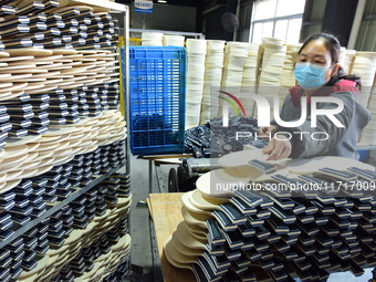 A worker produces table tennis bats for export in Lianyungang, China, on October 28, 2024. (