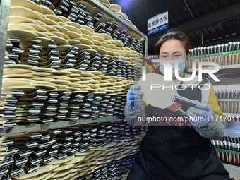 A worker produces table tennis bats for export in Lianyungang, China, on October 28, 2024. (