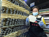 A worker produces table tennis bats for export in Lianyungang, China, on October 28, 2024. (