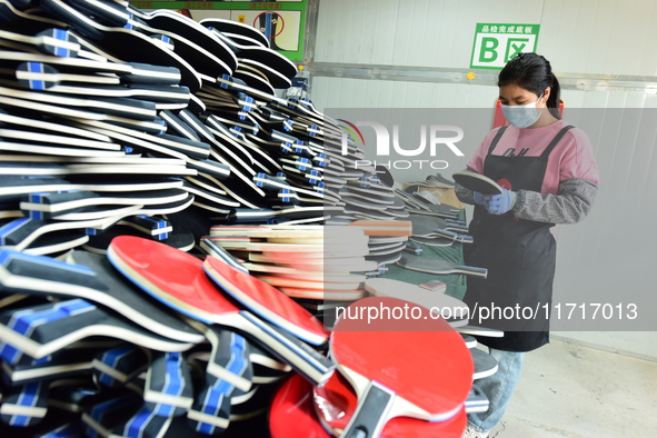 A worker produces table tennis bats for export in Lianyungang, China, on October 28, 2024. 