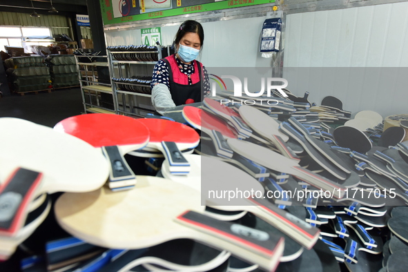 A worker produces table tennis bats for export in Lianyungang, China, on October 28, 2024. 