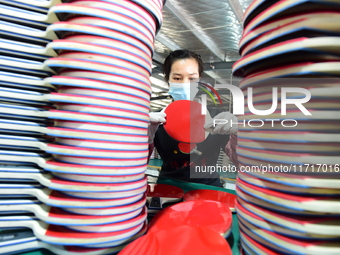 A worker produces table tennis bats for export in Lianyungang, China, on October 28, 2024. (