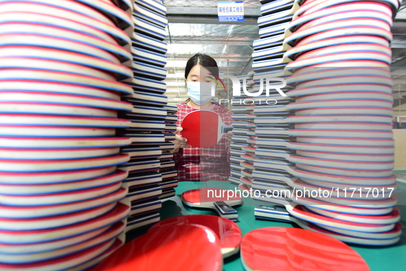 A worker produces table tennis bats for export in Lianyungang, China, on October 28, 2024. 