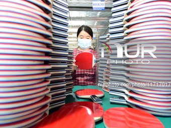 A worker produces table tennis bats for export in Lianyungang, China, on October 28, 2024. (