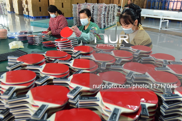 A worker produces table tennis bats for export in Lianyungang, China, on October 28, 2024. 