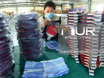 A worker produces table tennis bats for export in Lianyungang, China, on October 28, 2024. (