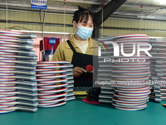 A worker produces table tennis bats for export in Lianyungang, China, on October 28, 2024. (