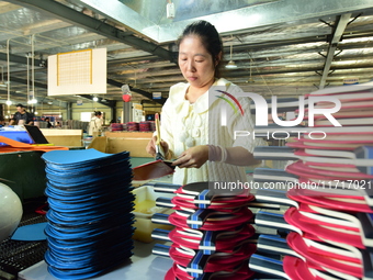 A worker produces table tennis bats for export in Lianyungang, China, on October 28, 2024. (